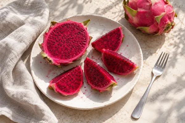 Irisan buah naga merah di piring sarapan