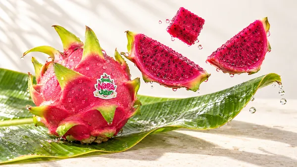 Buah naga merah utuh dan irisan di atas daun pisang